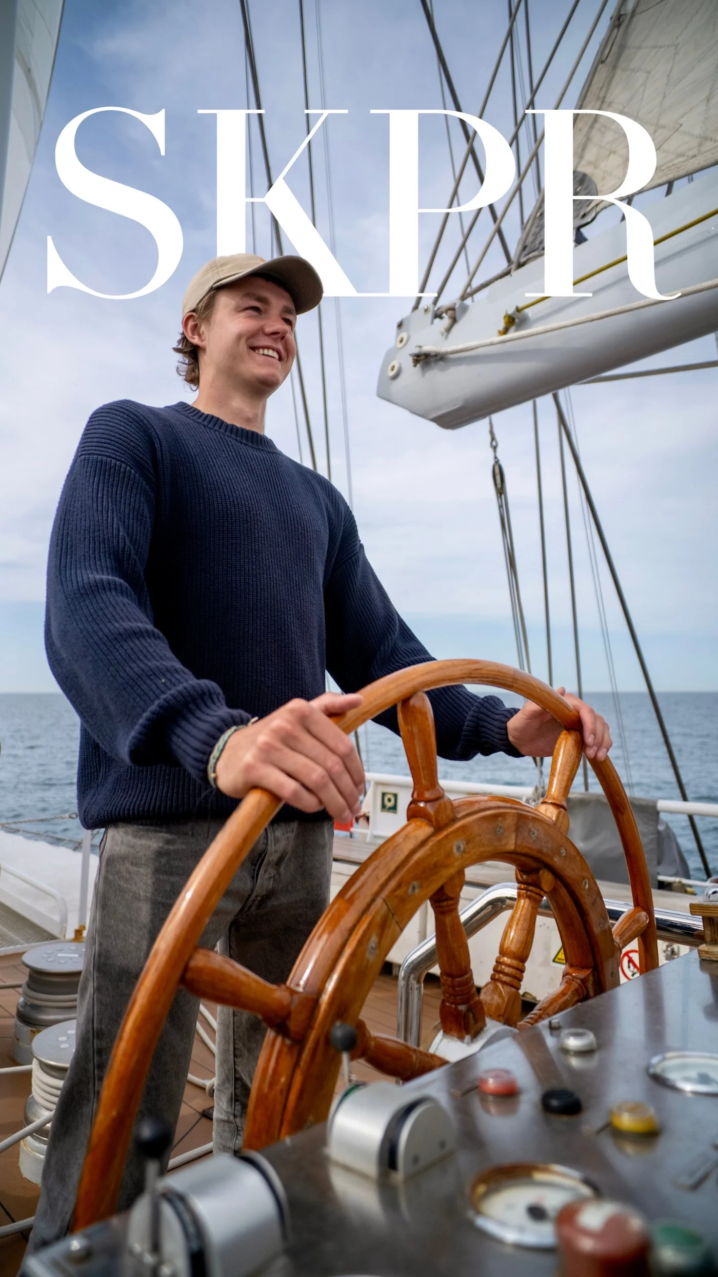 Skipper Visuals founder at the helm of a classic sailing yacht